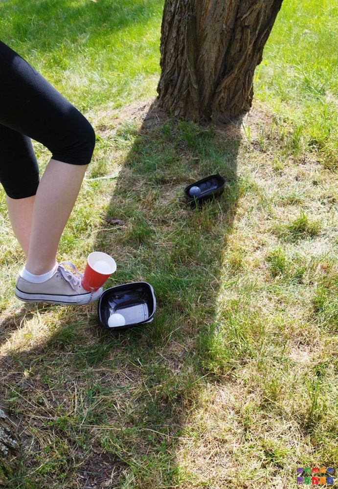 Zdjęcie przedstawiające stopę na tle trawnika. Na stopie znajduje się kubek a pod nią miseczka