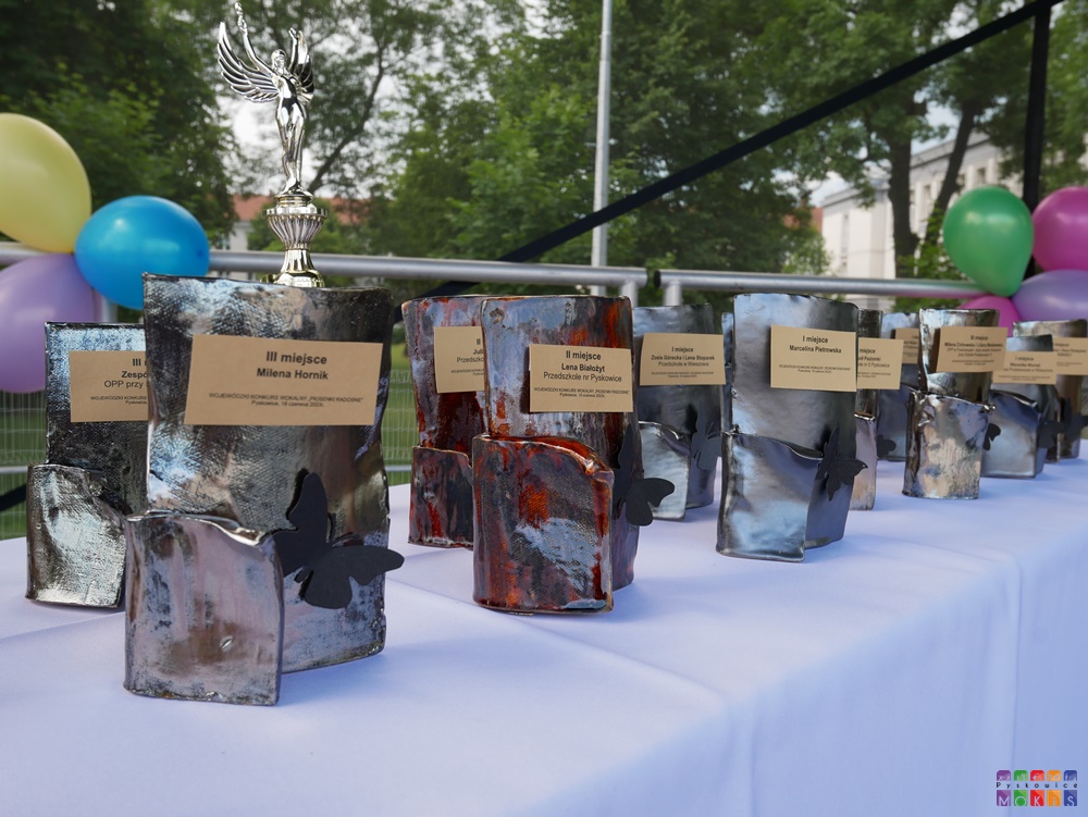 Zdjęcie przedstawiające stojące puchary nagrody na stoliku.