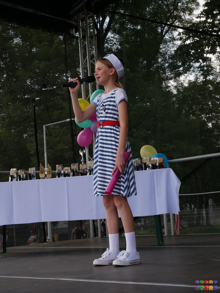 Zdjęcie przedstawiające śpiewające dziecko do mikrofonu