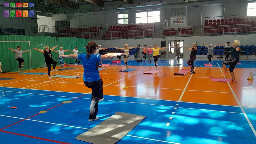 Zdjęcie przedstawia ćwiczące Panie - Seniorki na płycie głównej Hali Widowiskowo-Sportowej