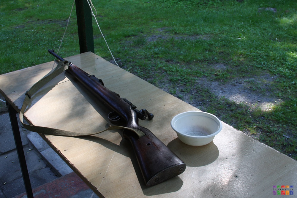 Zdjęcie przedstawiające leżącą na stole broń długą