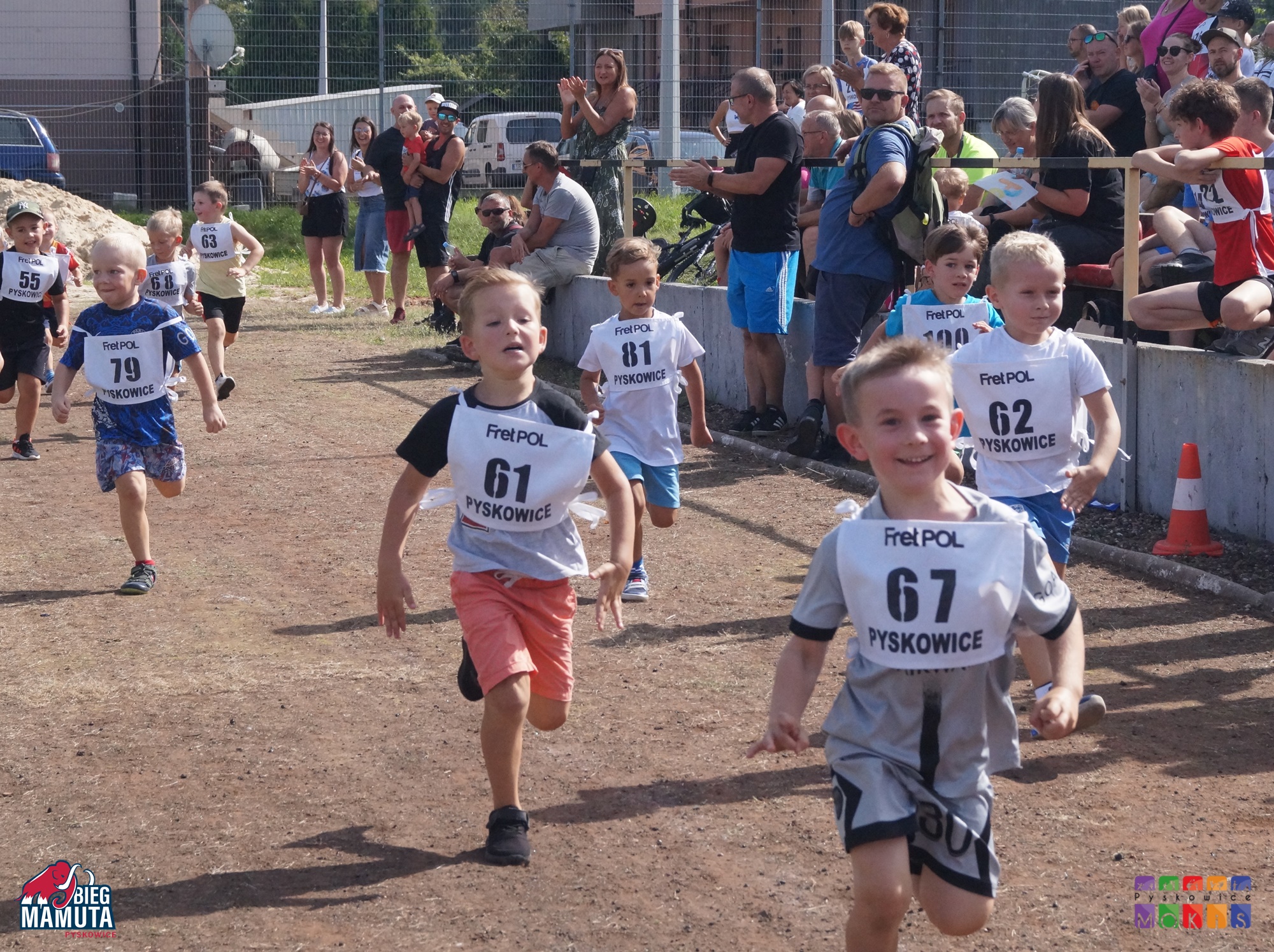Zdjęcie przedstawia biegnące po bieżni dzieci.