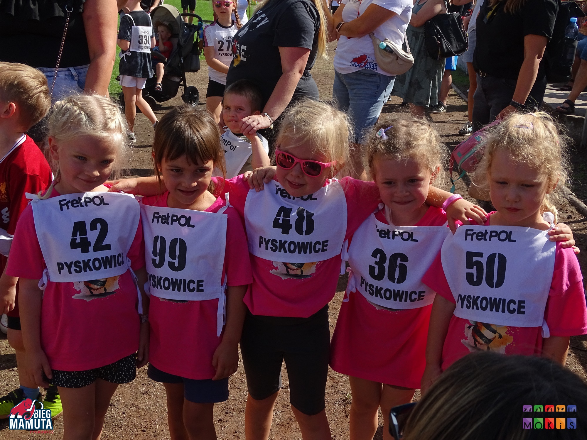 Zdjęcie przedstawia pięć dziewczynek ubranych na różowo ustawionych do zdjęcia.