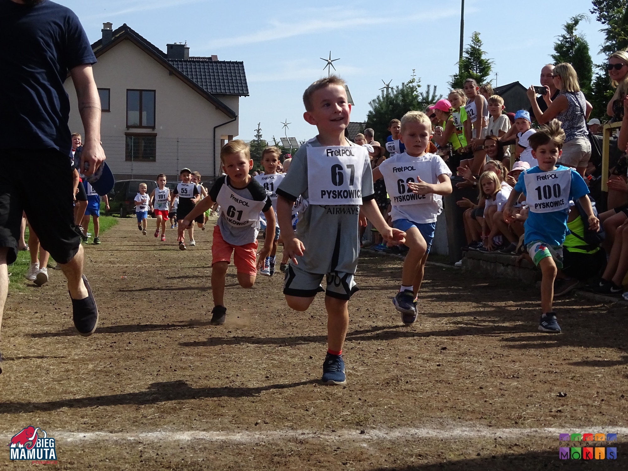 Zdjęcie przedstawia biegnące dzieci po bieżni.