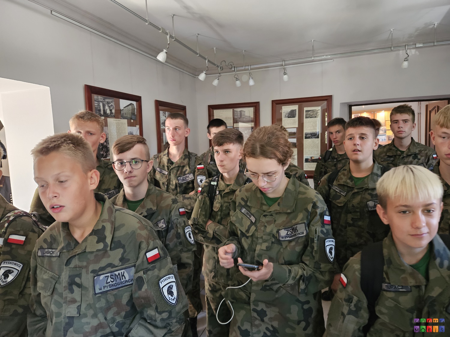 Zdjęcie przedstawia młodzież w mundurach stojących w pomieszczeniu wystawowym Centrum Wystawienniczego w Pyskowicach