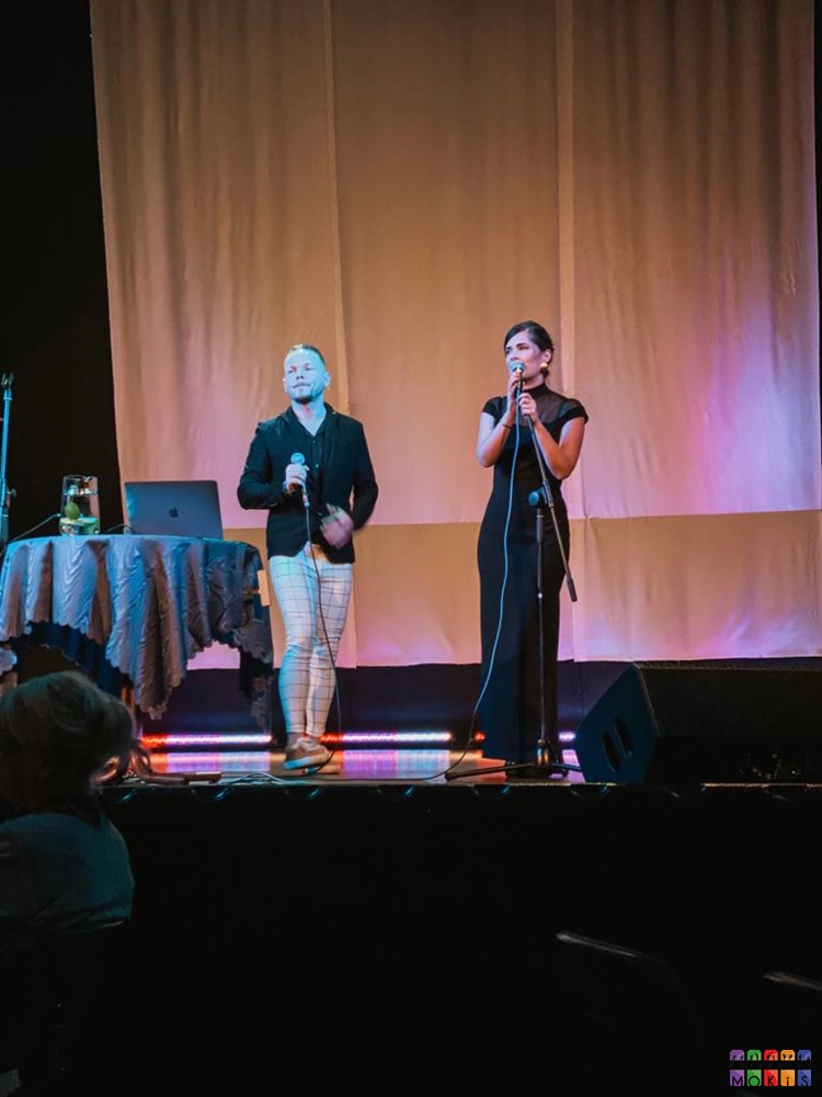 Zdjęcie przedstawiające mężczyznę i kobietę z mikrofonami na scenie.