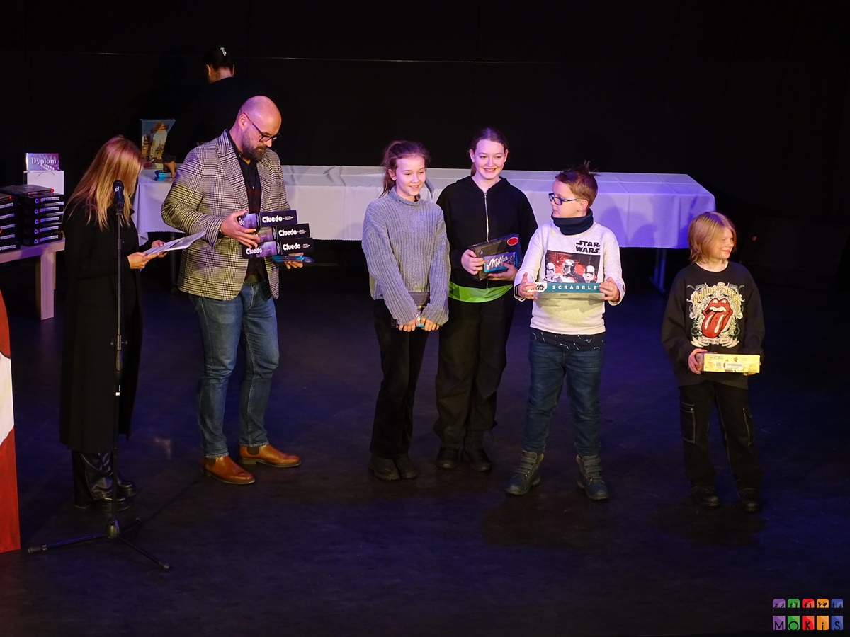 Zdjęcie przedstawiające wręczenie nagród dzieciom na scenie MOKiS-u przez Burmistrza miasta