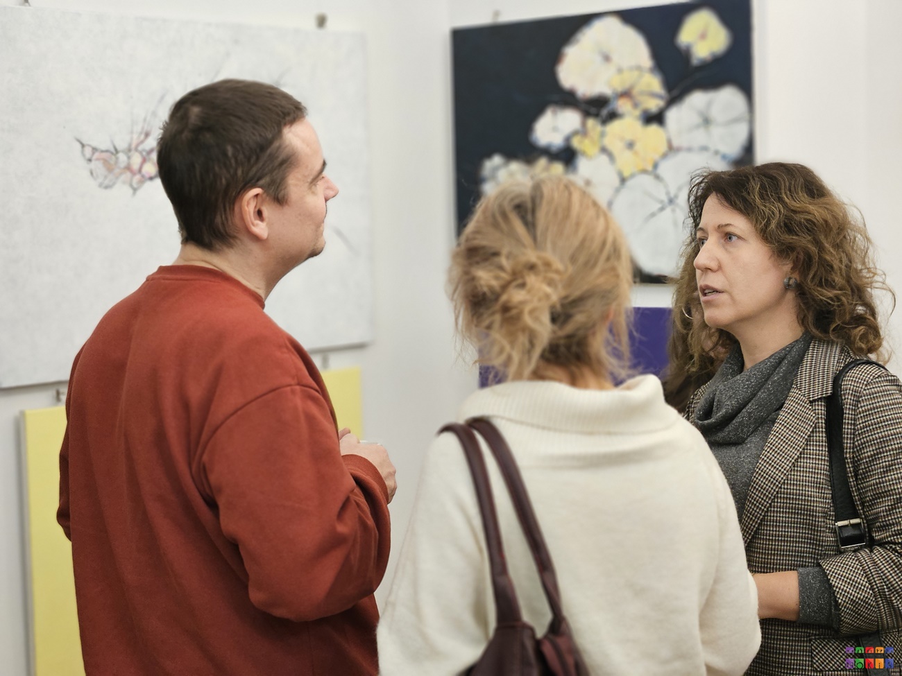 Zdjęcie przedstawiające ludzi rozmawiających ze sobą i oglądających wystawę w Centrum Wystawienniczym.