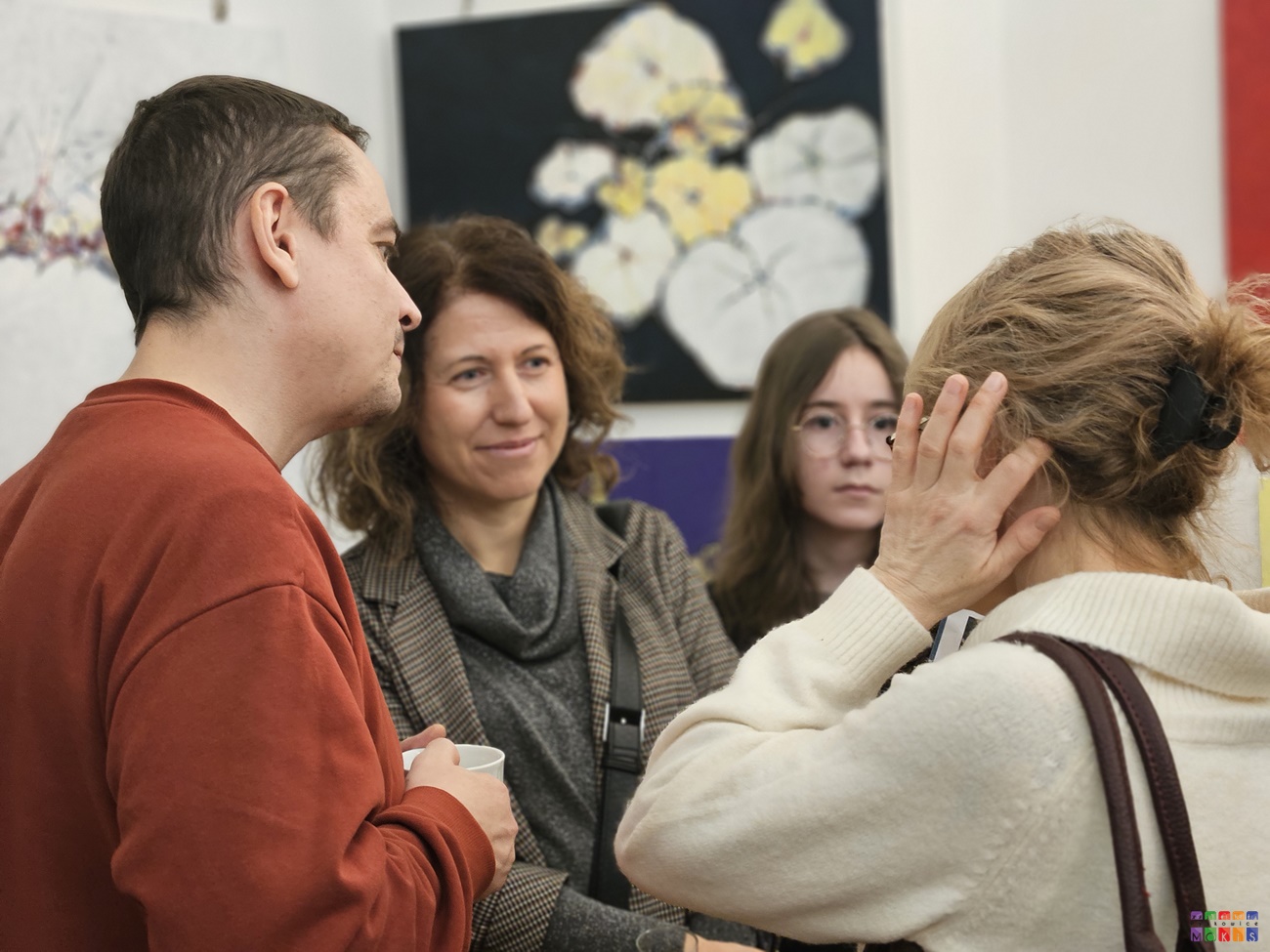 Zdjęcie przedstawiające ludzi rozmawiających ze sobą i oglądających wystawę w Centrum Wystawienniczym.