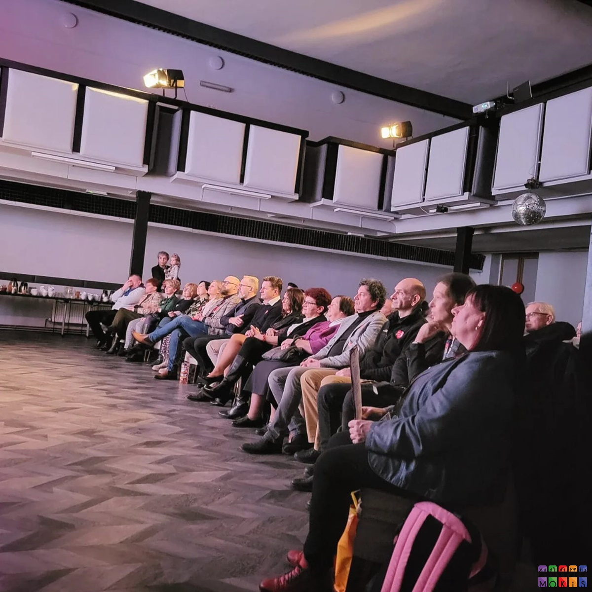 Zdjęcie przedstawia siedzących ludzi na widowni w sali widowiskowej MOKiS Pyskowice
